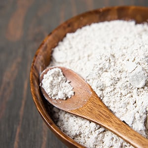 A wooden bowl filled with diatomaceous earth in a powder form. It helps promote blood lipids and help detoxify toxic metals.