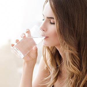 A woman drinking water.