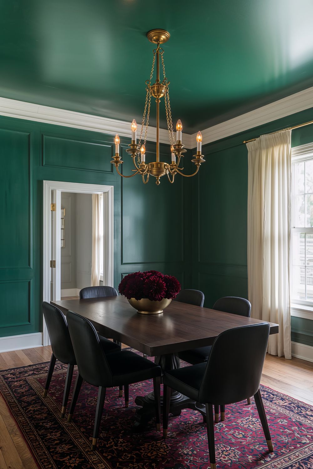 Dark Emerald Green Moody Dining Room With Brass Chandelier And Black Chairs