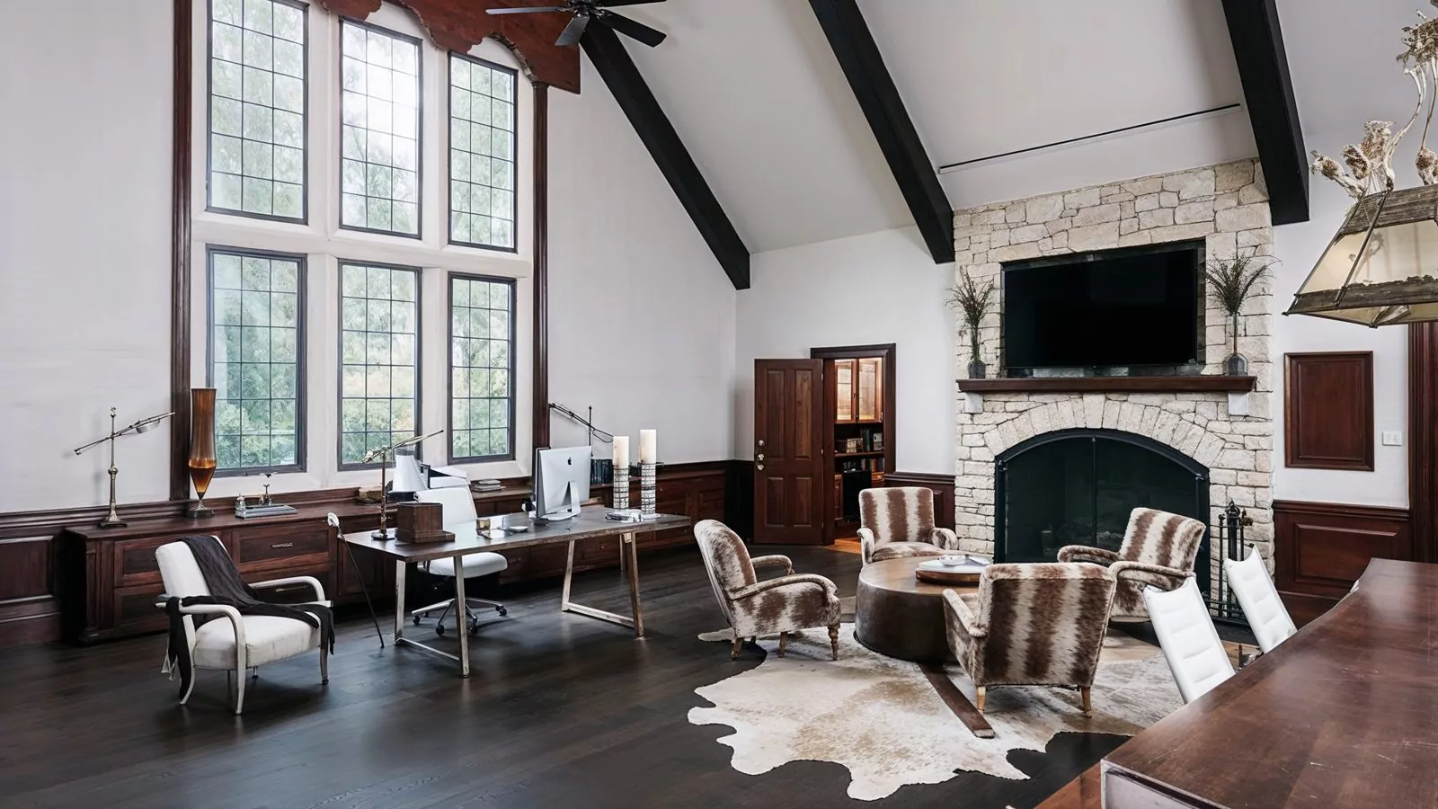 grand home office with vaulted ceilings and stone fireplace