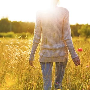 A woman walking through a field.