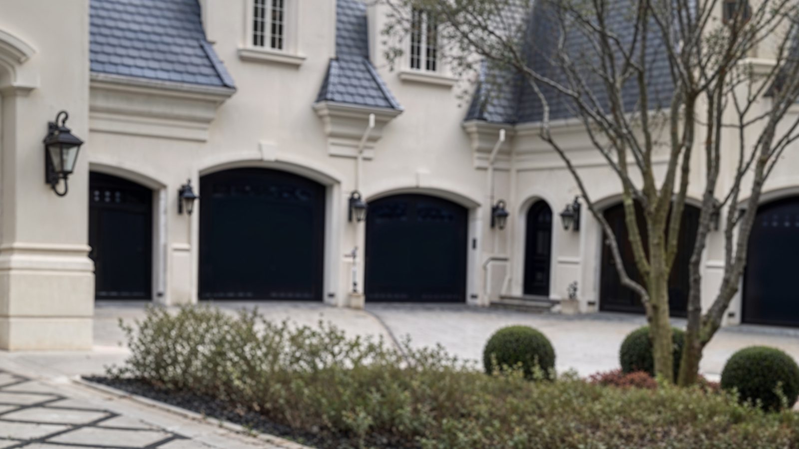 luxury multi car garage with black arched doors
