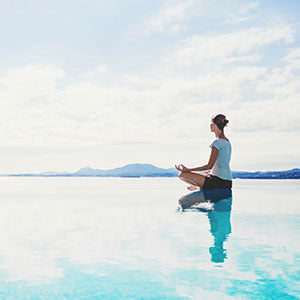 A is woman meditating. Maintaining a healthy weight is a great natural approach to PCOS.