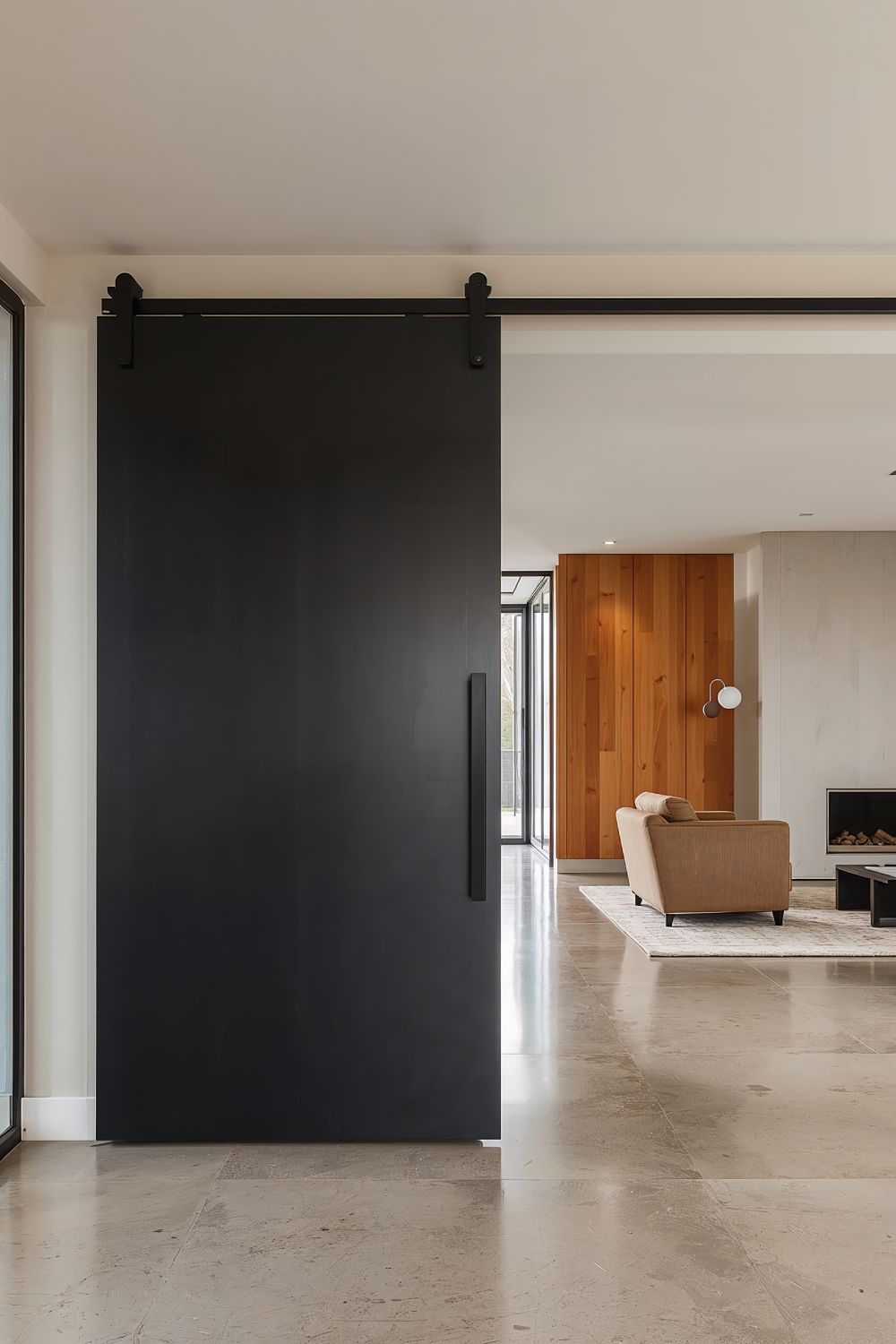 Oversized Black Pivot Door Creating Dramatic Entrance