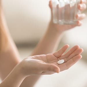 A woman taking a supplement.