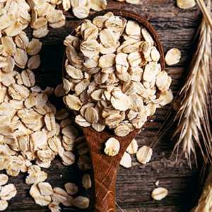 A wooden spoon full of oats. Foods like hummus, carrots, quinoa, and oats are ranked low in the glycemic index food chart.